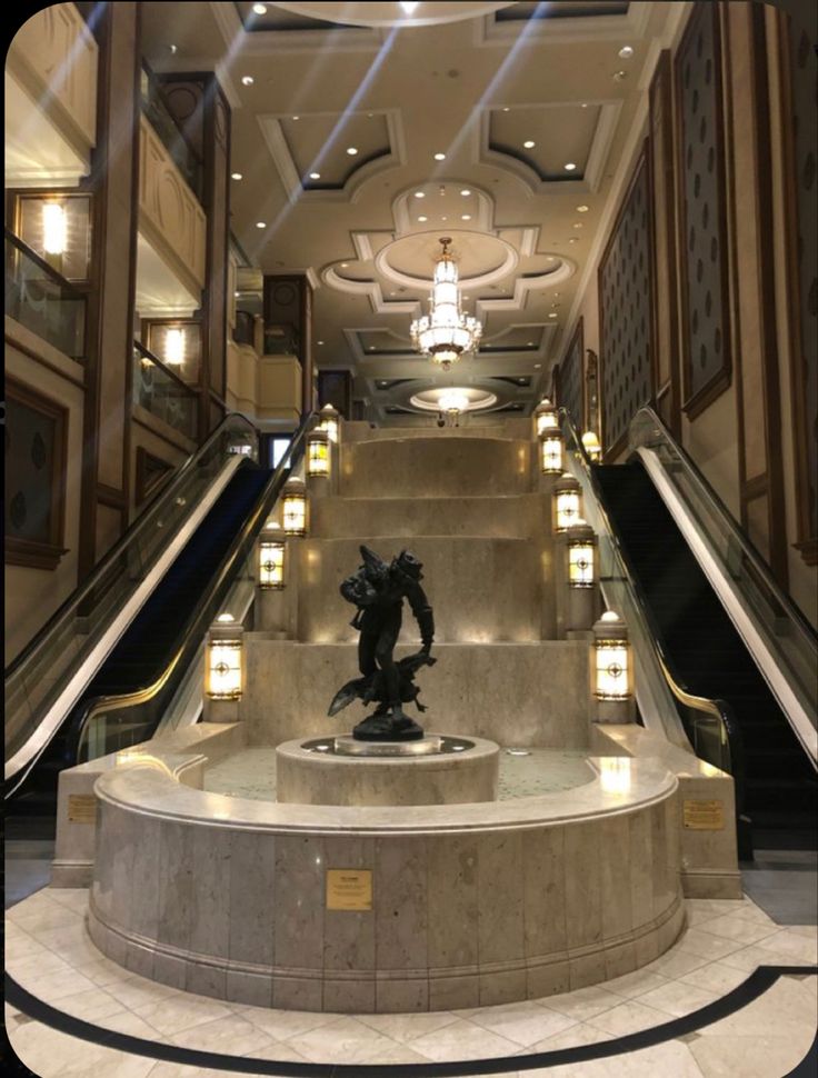 an escalator with a statue on it in a building