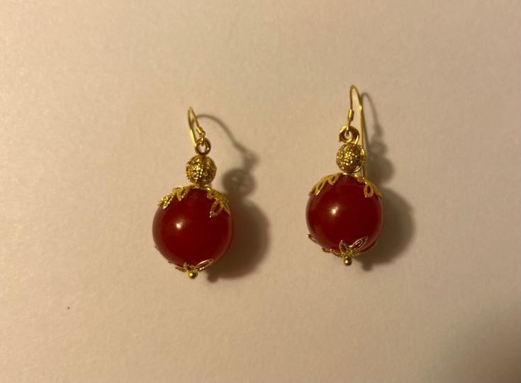 Beautiful, handmade, red-dyed jade earrings with a delicate golden leaf surrounding and nickel-free ear wire. Handmade Red Earrings For Formal Occasions, Red Carnelian Pierced Earrings, Red Carnelian Teardrop Earrings, Nickel-free Red Carnelian Earrings, Gold Carnelian Dangle Earrings, Red Carnelian Earrings With Ear Wire, Carnelian Round Earrings With Ear Wire, Red Carnelian Earrings Perfect As A Gift, Gold Carnelian Earrings With Ear Wire