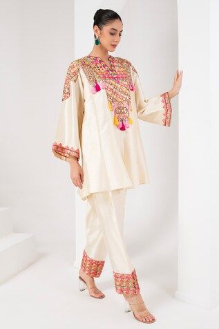 Ivory flared sleeves kurta with mirror, thread, tassel, sequin embroidered yoke. Paired with a salwar. - Aza Fashions Beige Festive Traditional Wear, Cream Kurta With Dabka Work, Transitional Beige Traditional Wear, Traditional Wedding Sharara With Embroidered Sleeves, Traditional Fitted Sharara With Embroidered Sleeves, Cream Traditional Wear For Spring Designer Occasion, Beige Silk Fitted Kurta, Fitted Silk Beige Kurta, Traditional Long Sleeve Cream Sharara