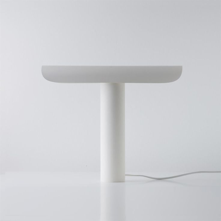 a white table with a light on it and a cord plugged into the top