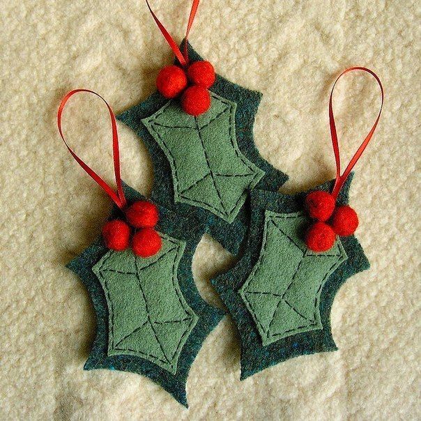 two green and red ornaments hanging on a white surface