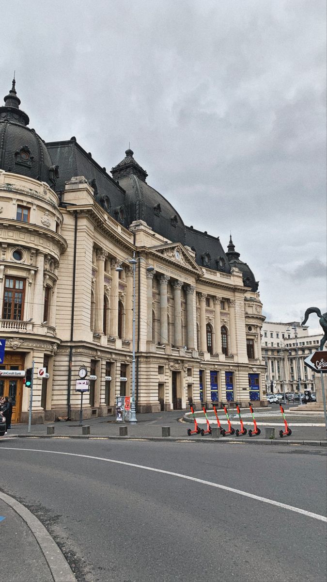 an old building is shown on the corner of a street with traffic cones in front of it