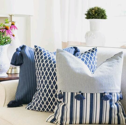 a couch with blue and white pillows on it