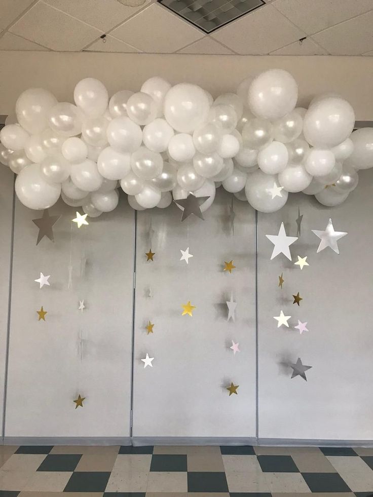 balloons and stars are hanging from the ceiling