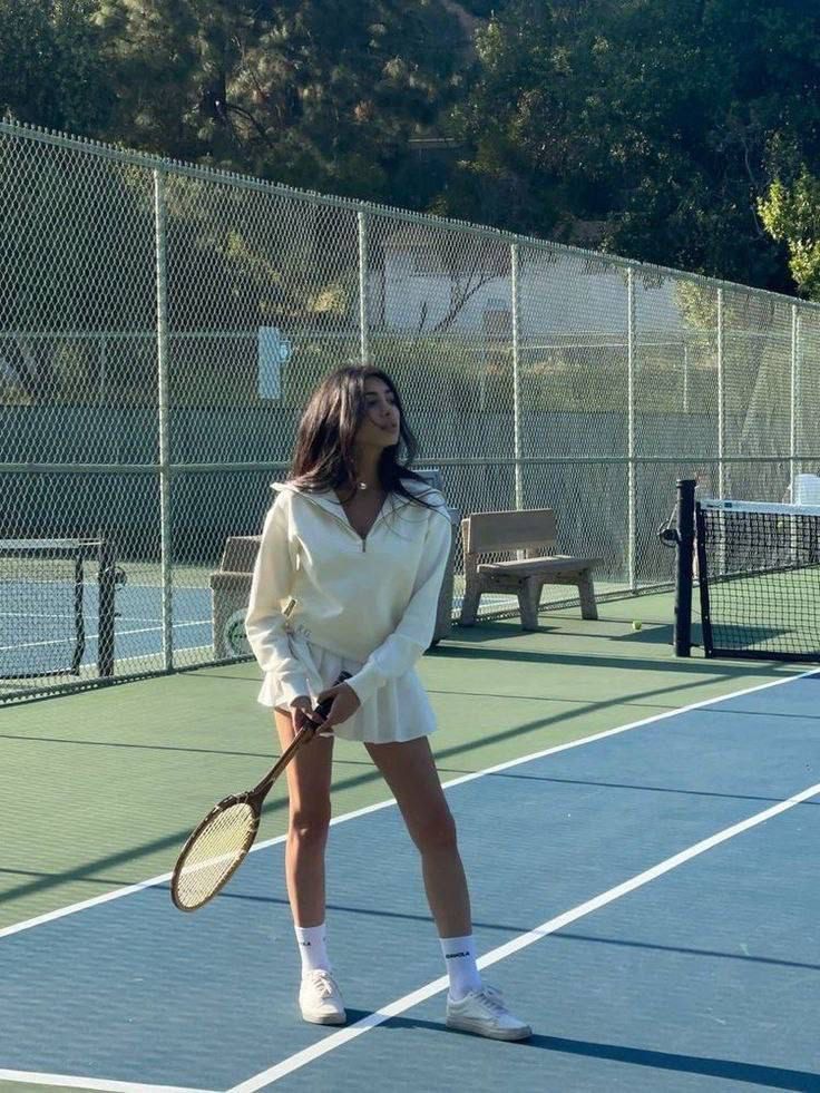 a woman standing on a tennis court holding a racquet