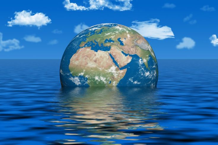 an image of the earth floating in the ocean with blue sky and clouds behind it