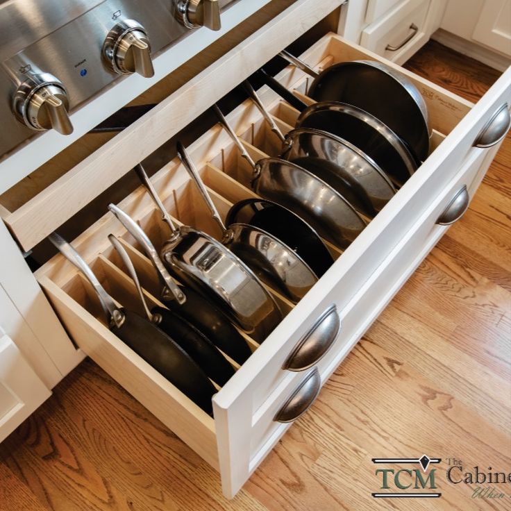 an open drawer with pots and pans in it