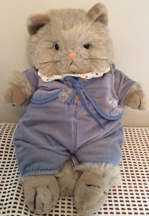 a stuffed animal is dressed up like a cat with clothes on it's body