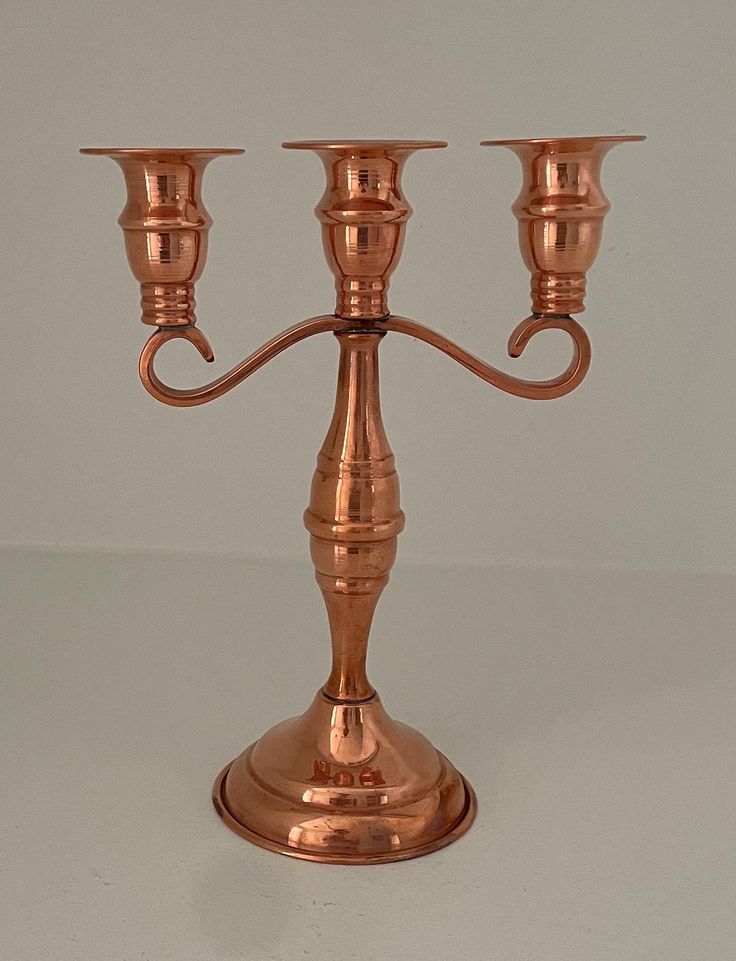 a copper candelabra with three candles on it