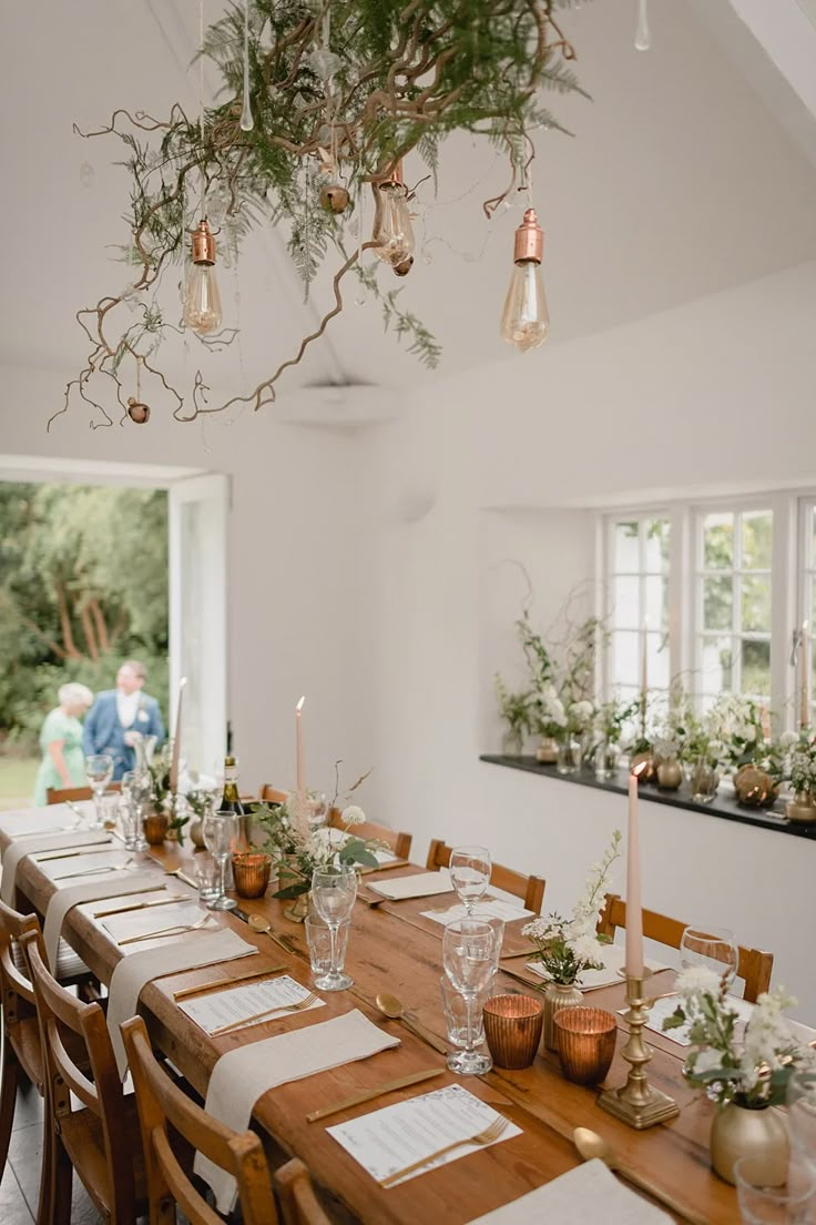 a dining room table is set with candles and place settings for the guests to sit at