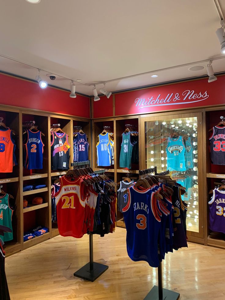 the inside of a clothing store with basketball jerseys on display