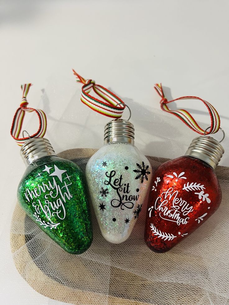 three christmas ornaments sitting on top of a table