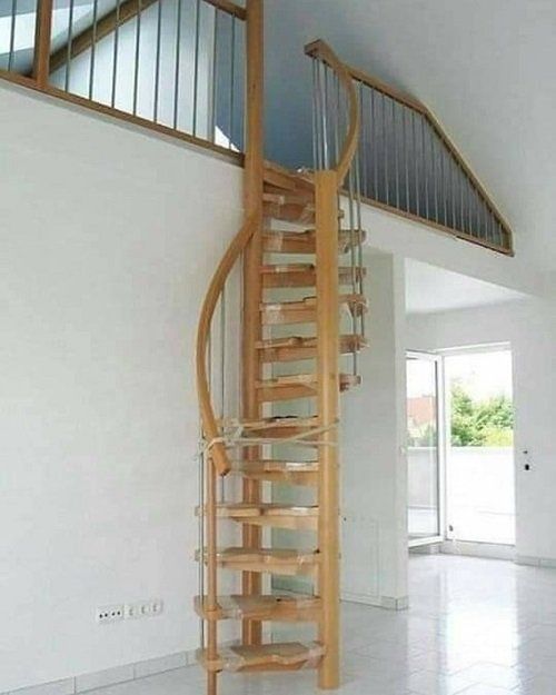 a wooden spiral staircase in an empty room