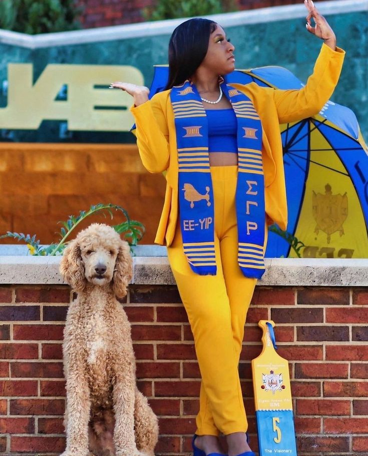 a woman in yellow and blue outfit standing next to a dog