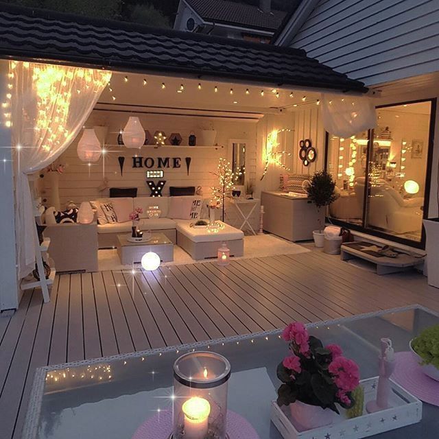 an outdoor living area is lit up with fairy lights