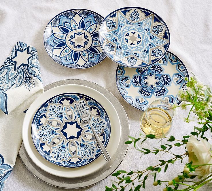 blue and white dinnerware on a table with flowers