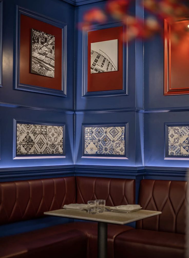 a booth with booths and pictures on the wall behind it in a restaurant or bar