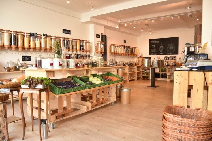 the inside of a store with lots of wooden shelves and baskets on the counter top