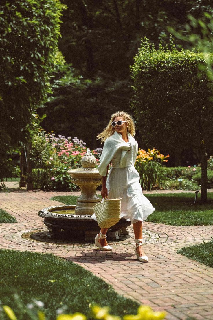 a woman standing in front of a fountain