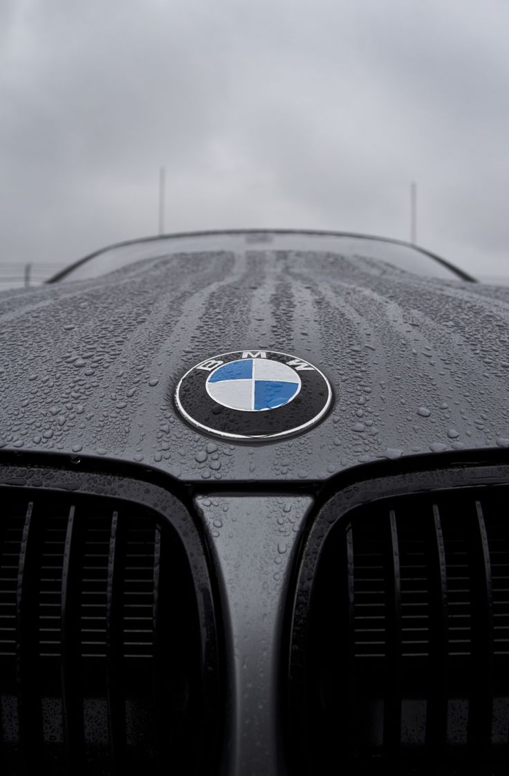 the front end of a bmw car with rain drops on it's grills