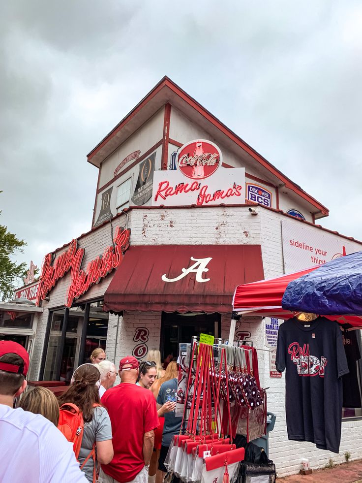 a group of people standing in front of a red and white building with an awning