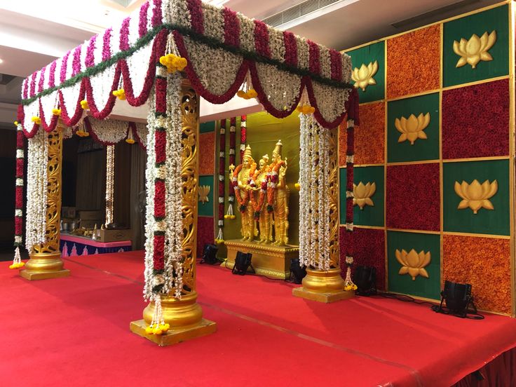 a decorated stage with red carpet and gold pillars