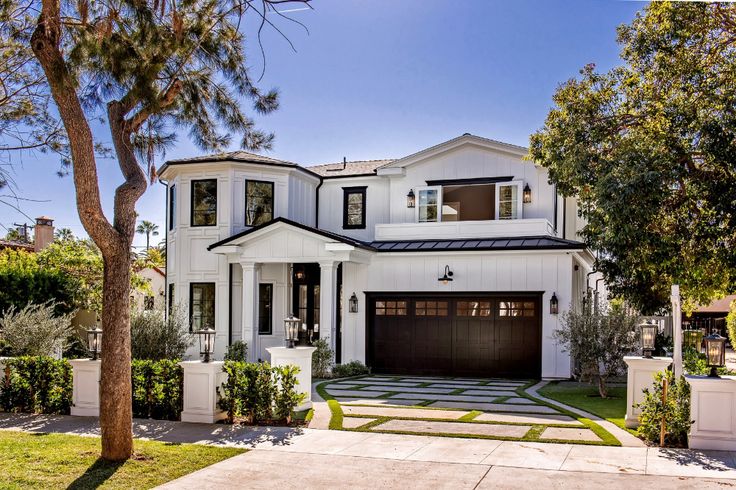 a large white house with black garage doors