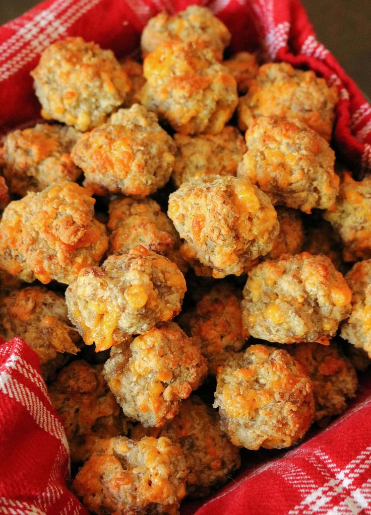 a basket filled with meatballs sitting on top of a red and white checkered cloth