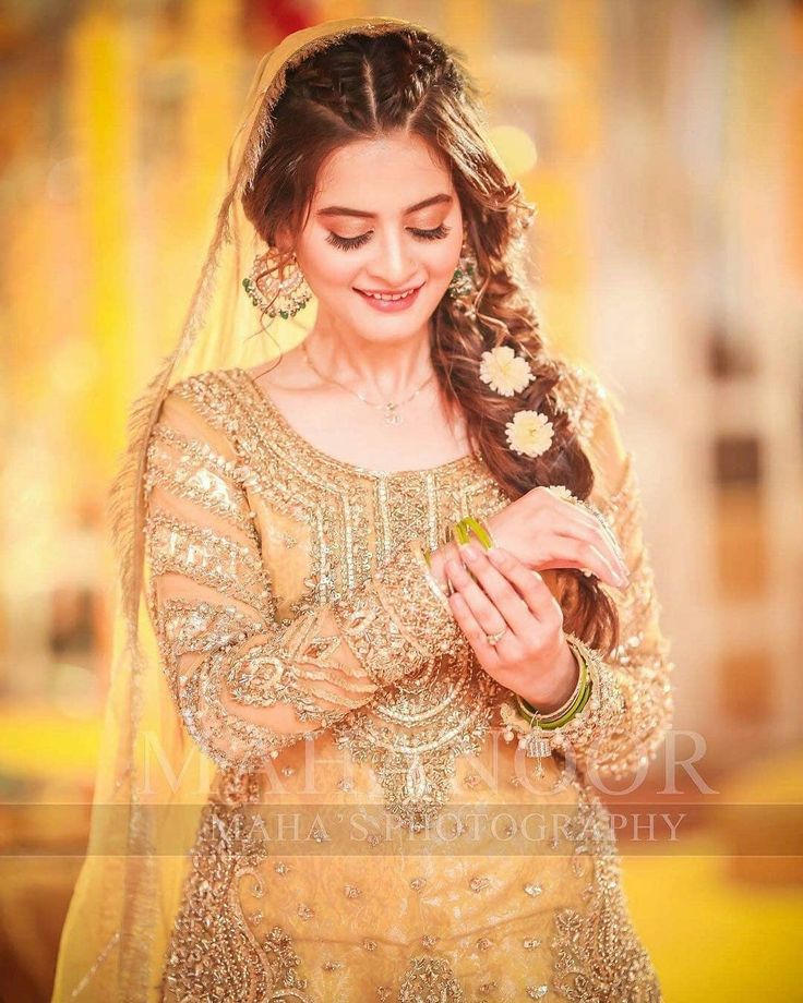 a woman in a wedding dress is smiling and looking down at her hand while wearing a veil