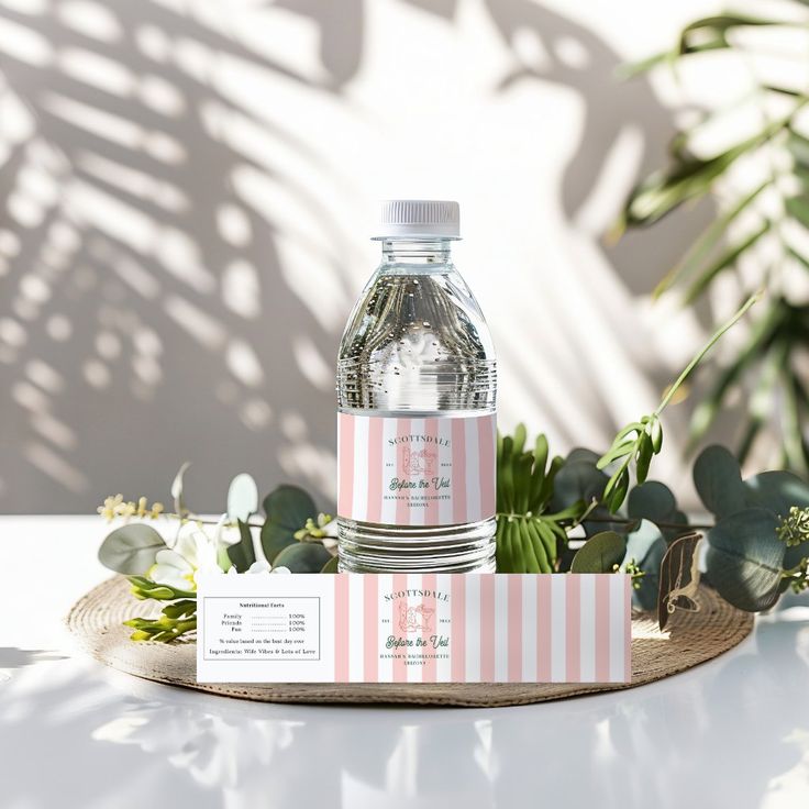 a bottle of water sitting on top of a wooden tray next to plants and cards