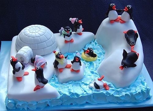 a cake with penguins and an igloose on it