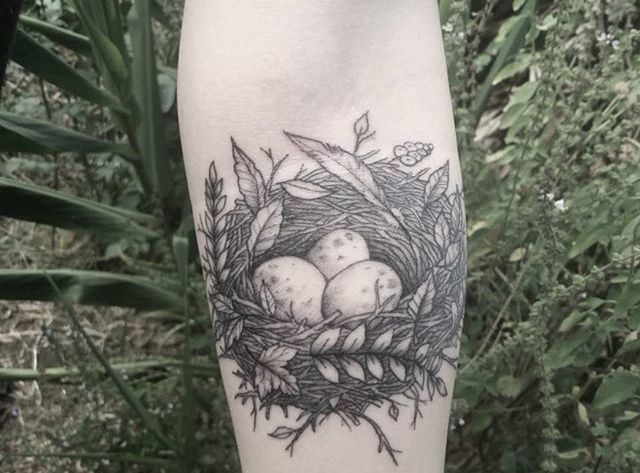 a bird's nest with three eggs in it on the left forearm tattoo design