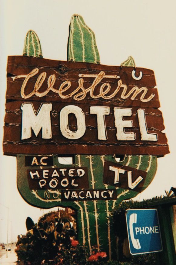 the western motel sign is painted green and white