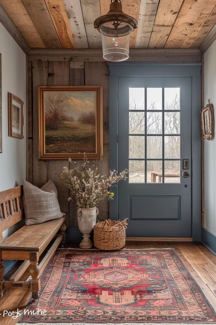 a room with a blue door and a rug on the floor next to a wooden bench