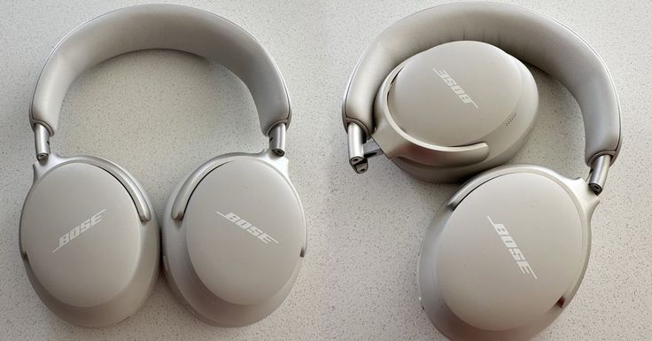 two silver headphones sitting next to each other on top of a white countertop