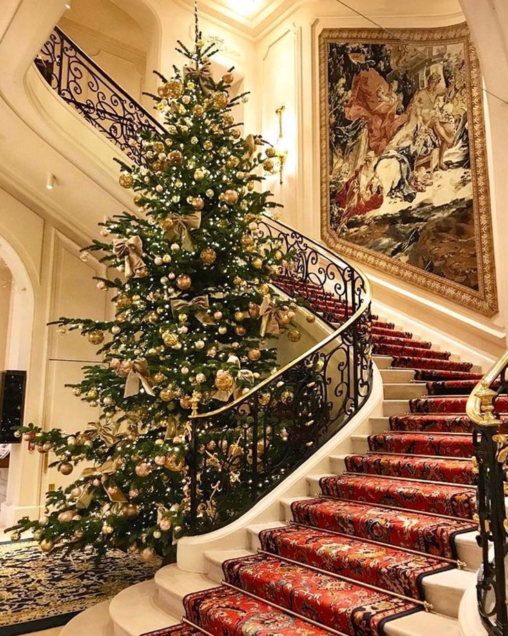 a christmas tree sitting on top of a set of stairs next to a stair case