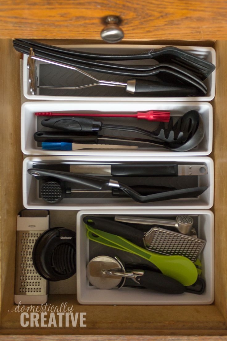 an organized drawer with scissors, combs and other office supplies in the bottom compartment