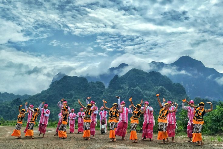 a group of people standing on top of a dirt road