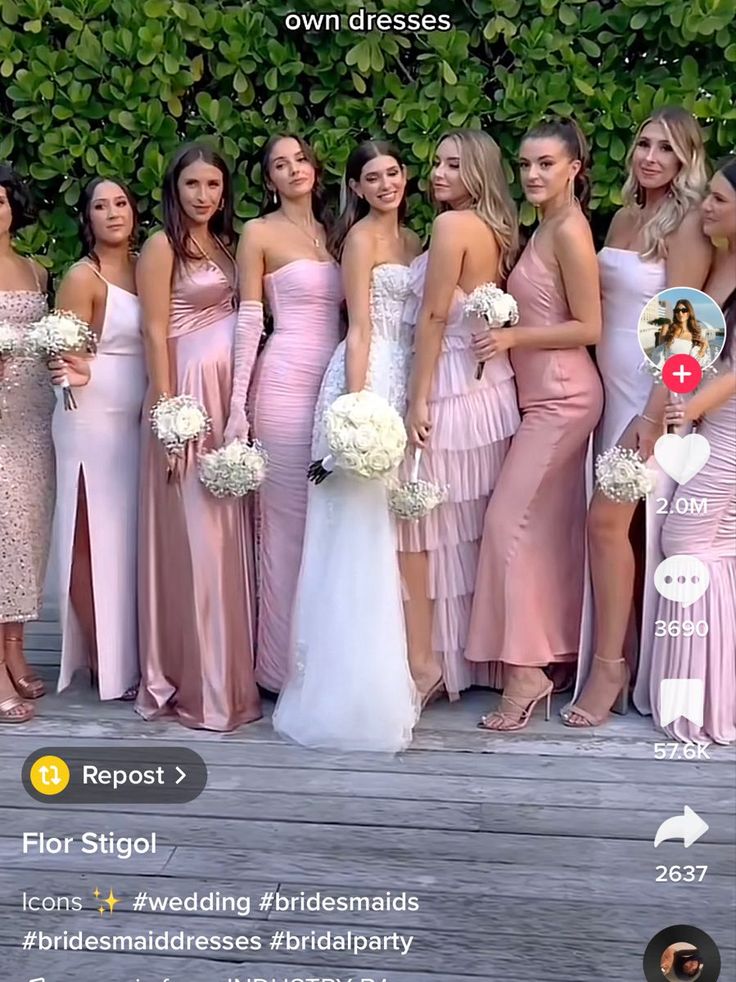 a group of bridesmaids posing for a photo on a wooden deck with greenery in the background