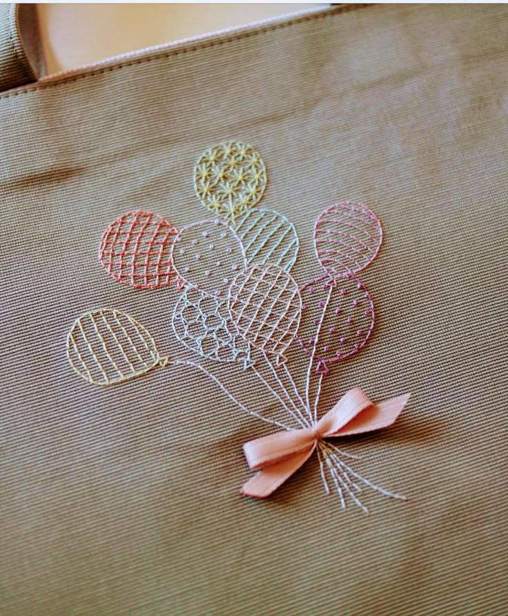 an embroidered bag with balloons on it