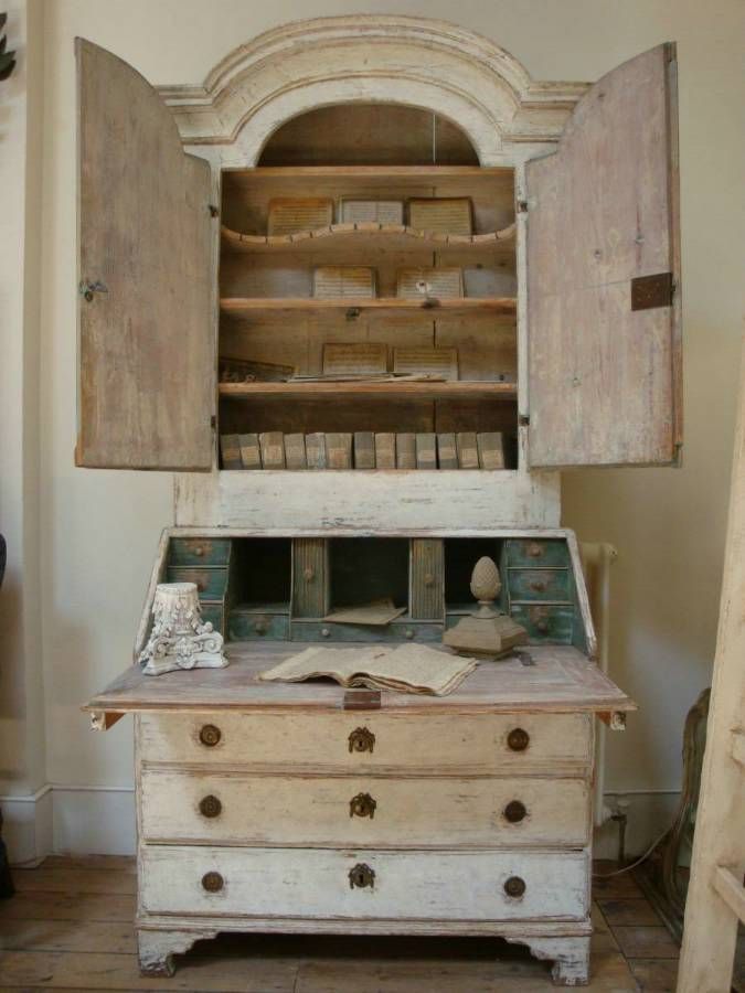 an old wooden cabinet with books on top