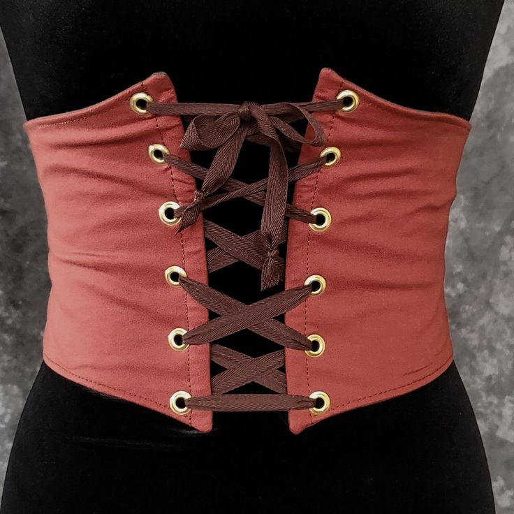 "This waist cincher is made in 100% Cotton in BURNT ORANGE. The perfect compliment to your Witch, Pirate, Renaissance, Medieval or other fantasy cosplay costume. It is lined with cotton duck and it has spring steel boning in the front for stability and to reinforce the grommets (this boning has some flex to it so it will move with you some as well). A very comfortable, yet sturdy piece.   Measure your waist as the smallest point (typically just about the belly button) and choose from the following sizes:  X-SMALL: Waist 25.5 - 28 inches (64 - 71 cm) SMALL: Waist 28 - 31 inches (71 - 79 cm)  MEDIUM: Waist: 30 - 33 inches (76 - 84 cm) LARGE: Waist: 32 - 35 inches (81 - 89 cm) X-LARGE: Waist: 34 - 37 inches (86.5 - 94 cm)  XXLARGE: Waist 36 - 39 inches (91.5 - 99 cm) ✿✿THIS PIECE IS MADE TO O Tavern Wench, Witch Pirate, Pirate Witch, Medieval Tavern, Steampunk Fantasy, Witch Costume, Spring Steel, Waist Cincher, Women's Costumes