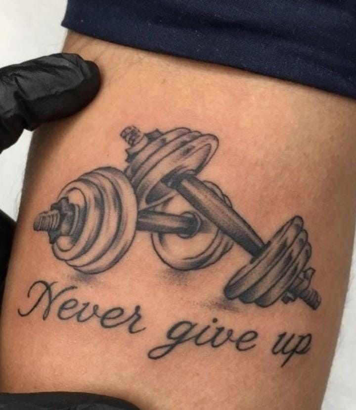 a tattoo that says never give up with dumbs on it