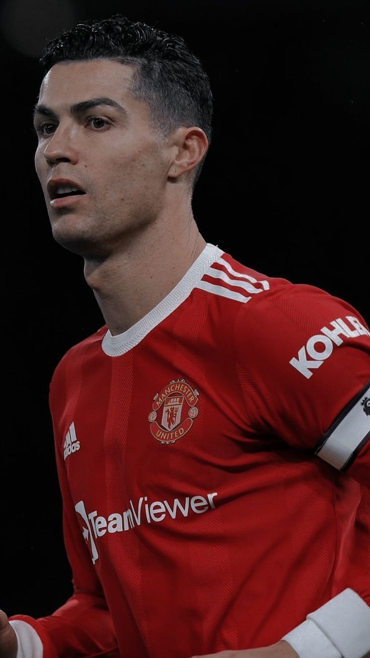 a man in a red shirt holding a soccer ball