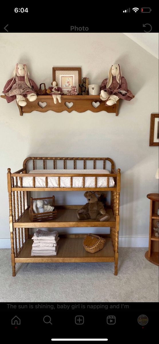 a baby crib in the corner of a room next to a shelf with pictures on it