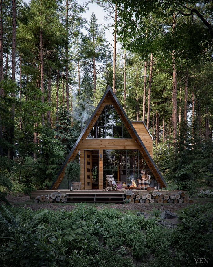 a - frame cabin in the woods surrounded by tall trees and greenery is perfect for relaxing