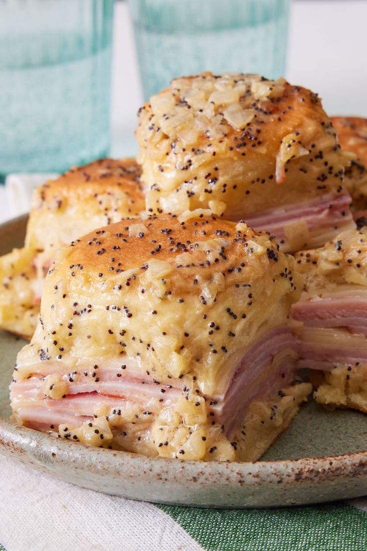 ham and cheese sliders on a plate with two cups in the backgroud