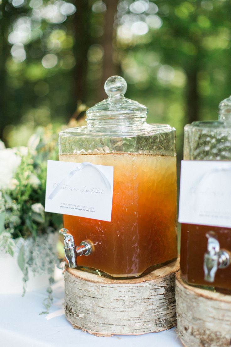 two jars filled with liquid sitting on top of a table