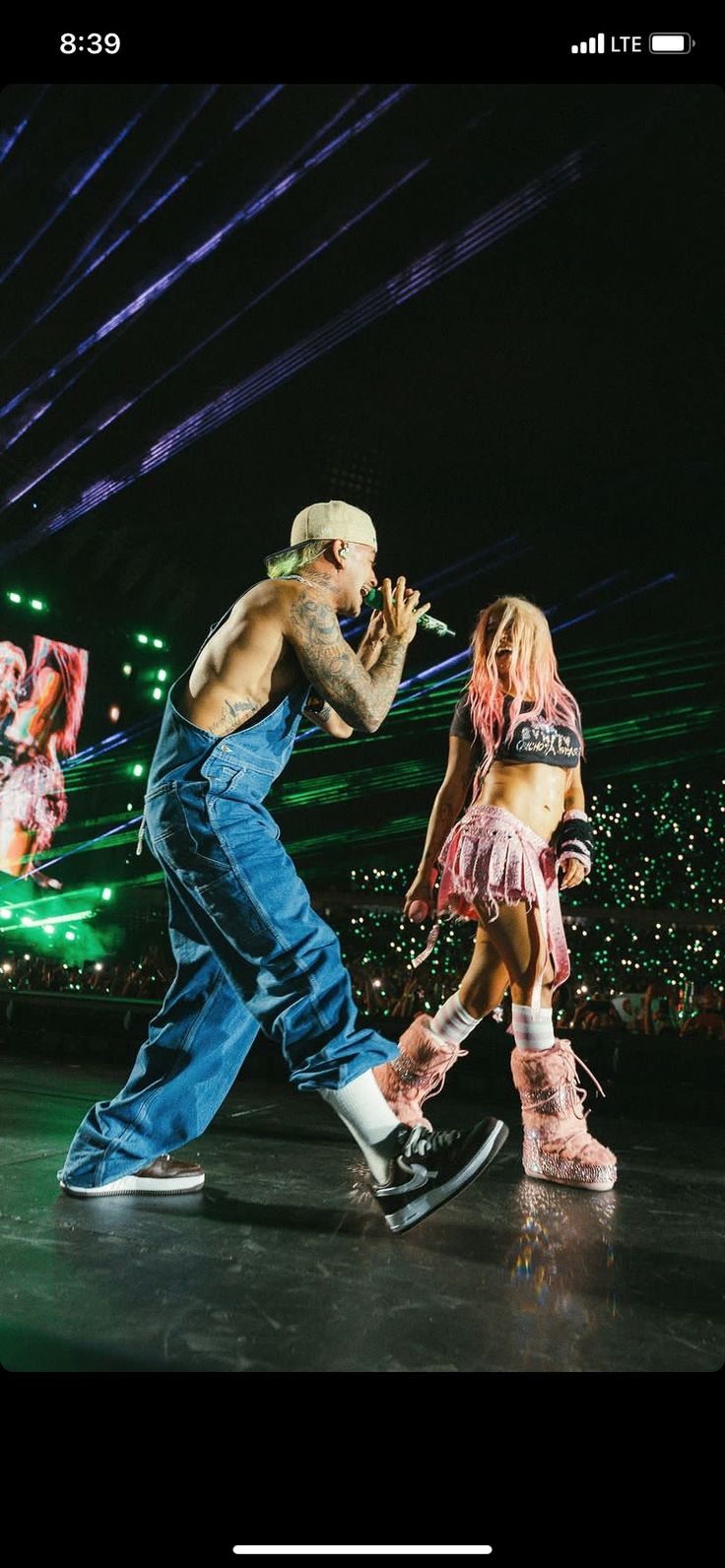 a man and woman are performing on stage with lights in the back ground behind them