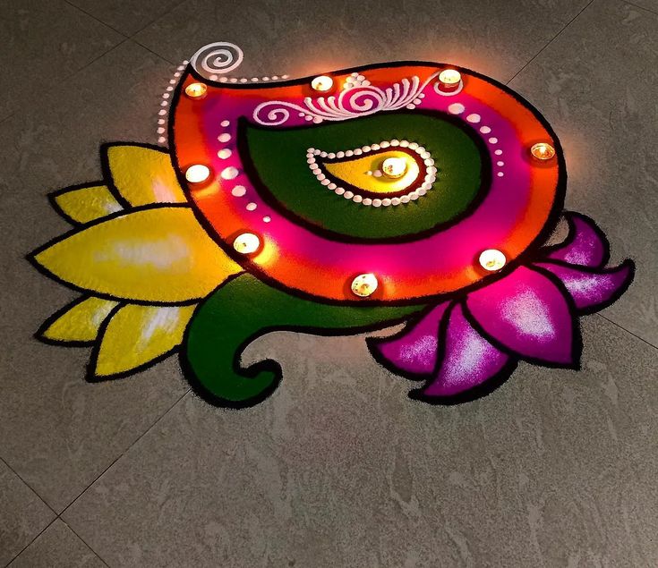 an artistically designed rangolite design on the ground with flowers and lights around it